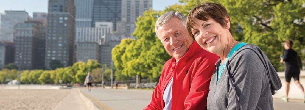 Man and Woman in Jogging suits sitting on bench