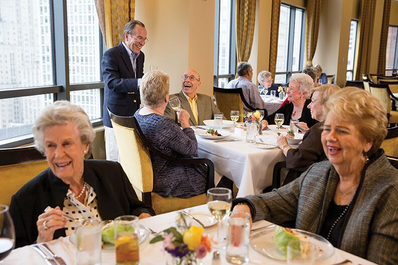People at line covered dining tables talking and drinking