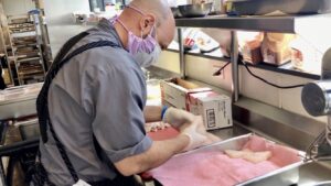 man with mask prepping food