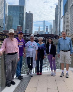 6 people standing near railing overlooking river