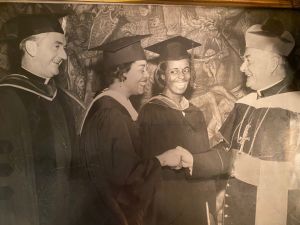 Mary shaking hands with the Archbishop during her graduation from the University of San Francisco.