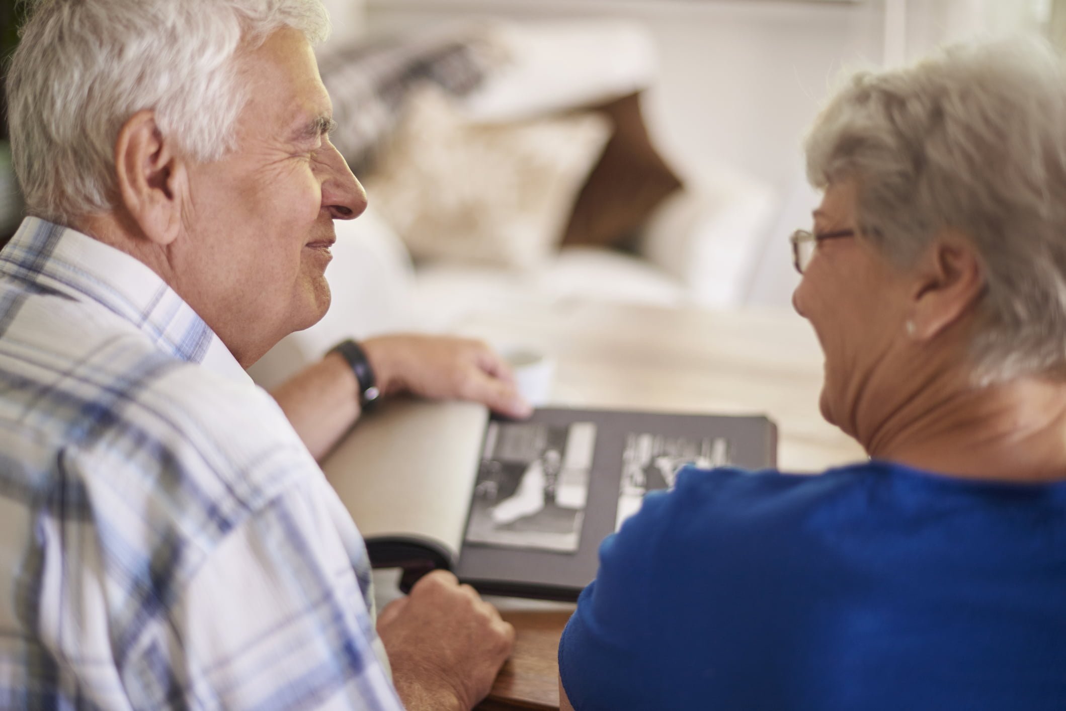 Couple of elder couple reminiscing their past couple looking at photo album