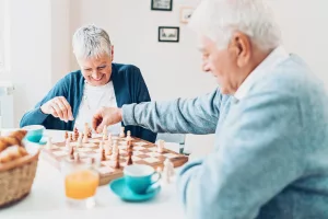 A couple play chess together over coffee