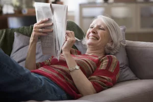 Lady on Couch Doing Crossword Puzzle