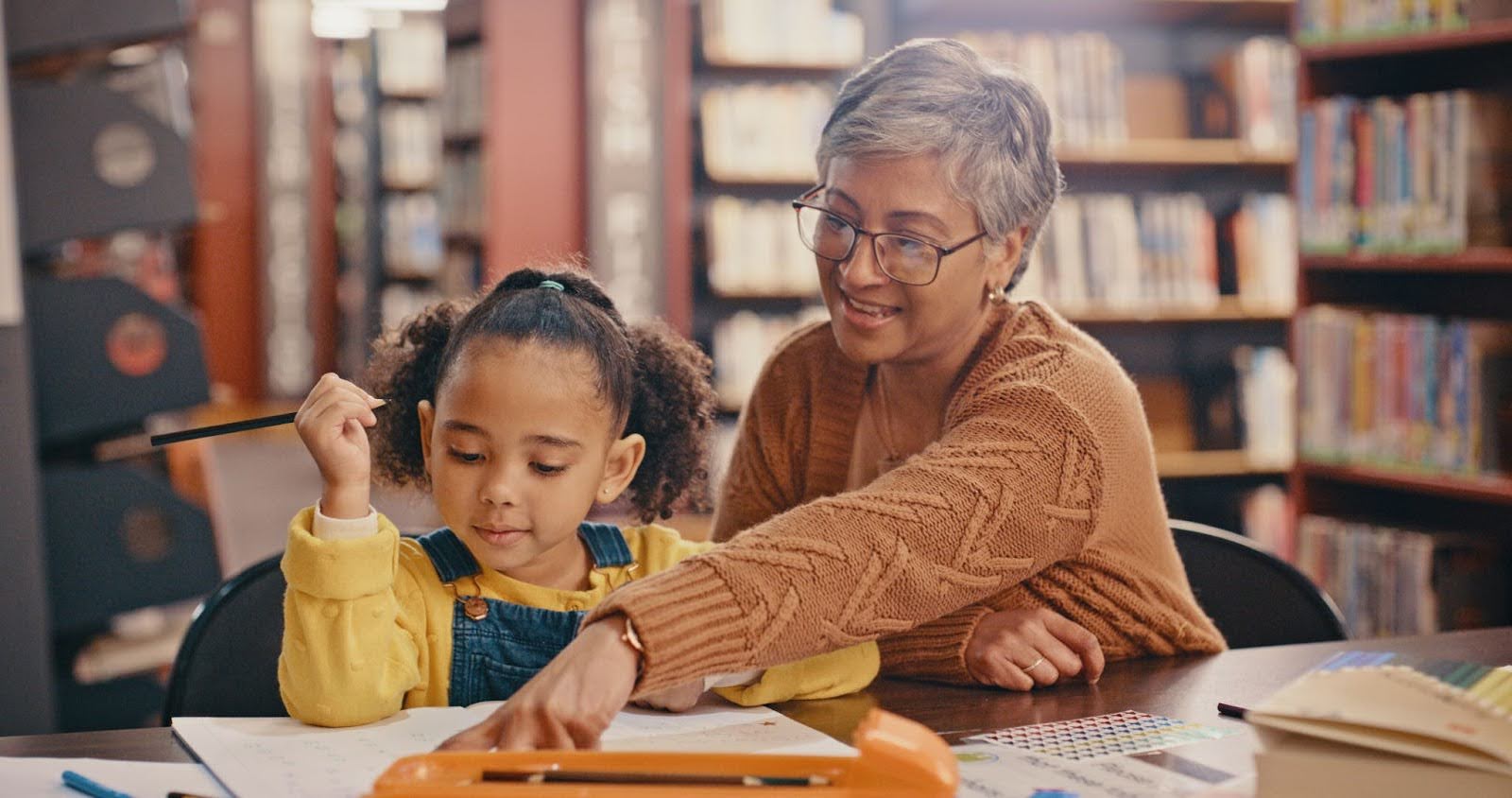 Senior woman volunteer mentoring a young girl Senior woman volunteer mentoring a young girl