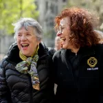 Two senior women laughing outdoors at The Clare