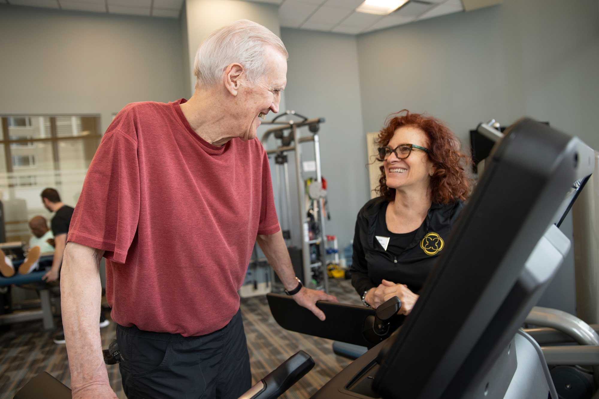 fitness instructor overseeing a senior man's exercise