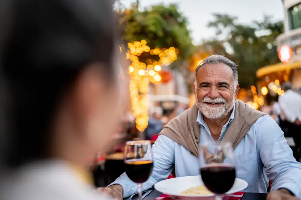 a group of seniors having wine while sitting outside at a downtown restaurant