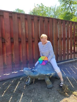 Resident Dorothy sitting on turtle statue showing her story of resilience at The Clare in Chicago, IL.