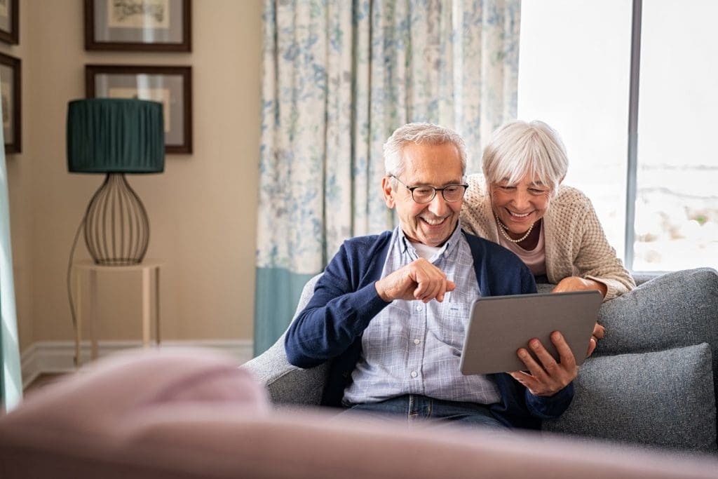senior couple looking at ipad