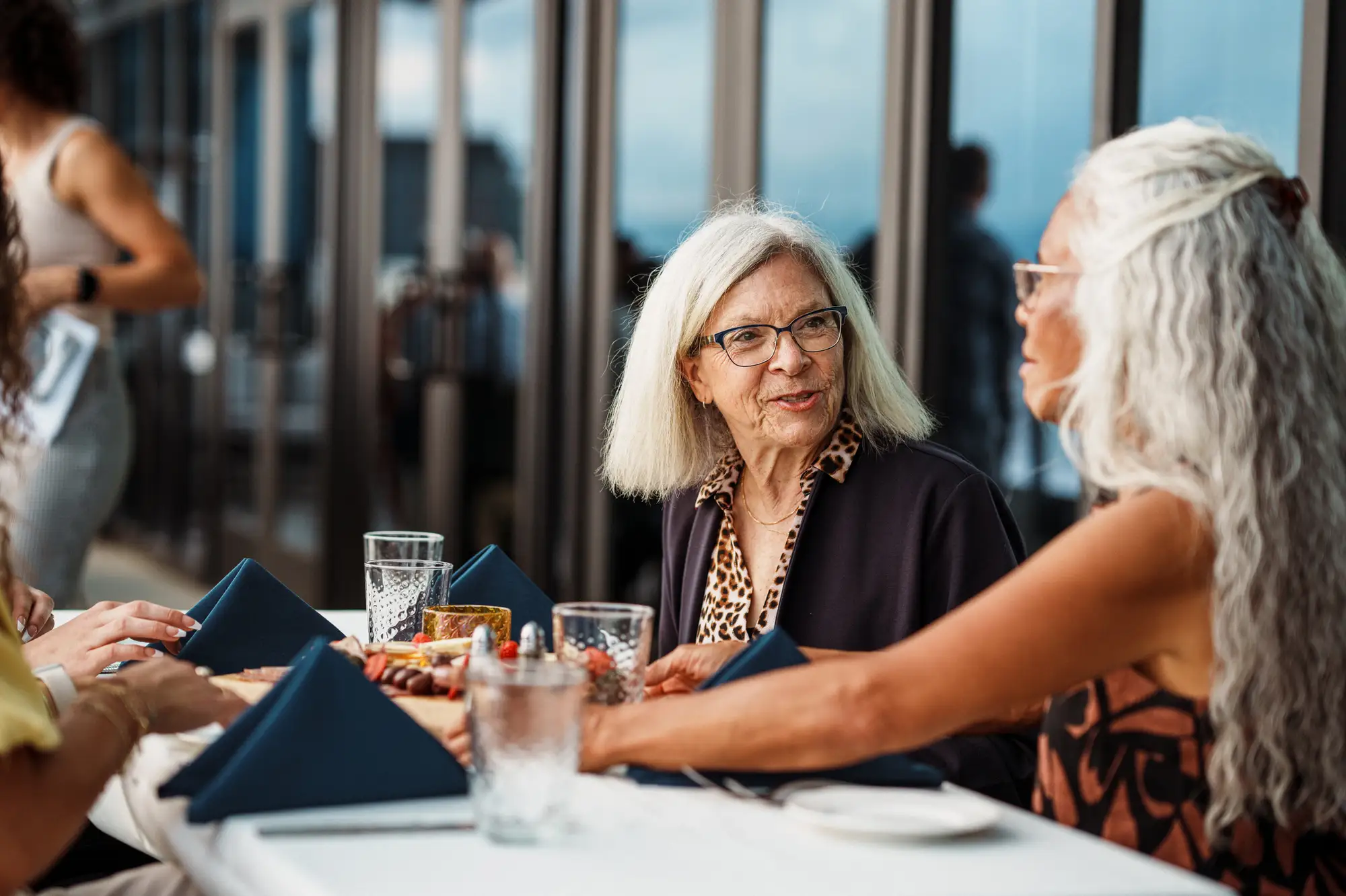 Senior women having dinner and explaining senior independent living.