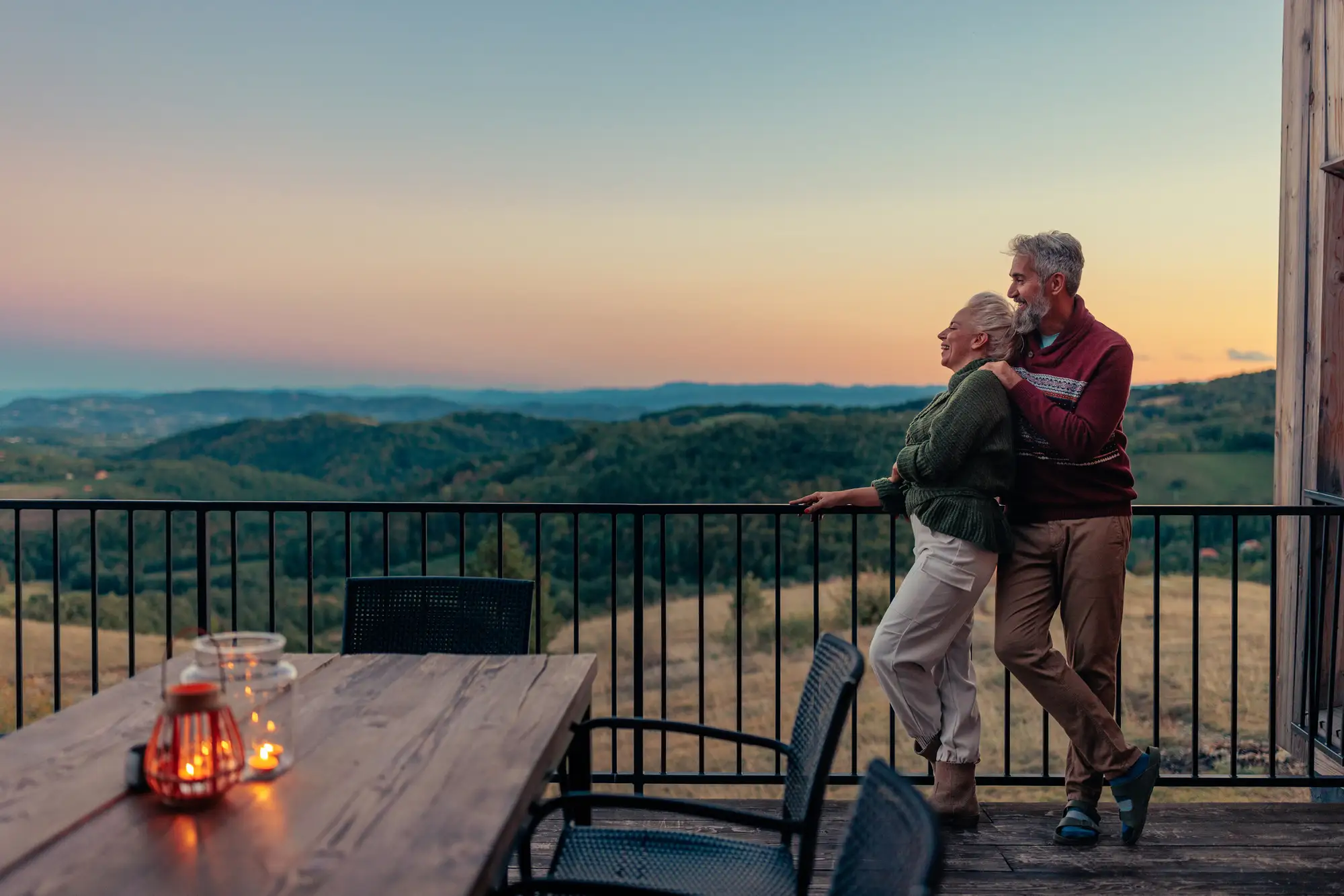 Retired senior couple on back deck in mountains exploring the best vacations for seniors in Chicago at The Clare.