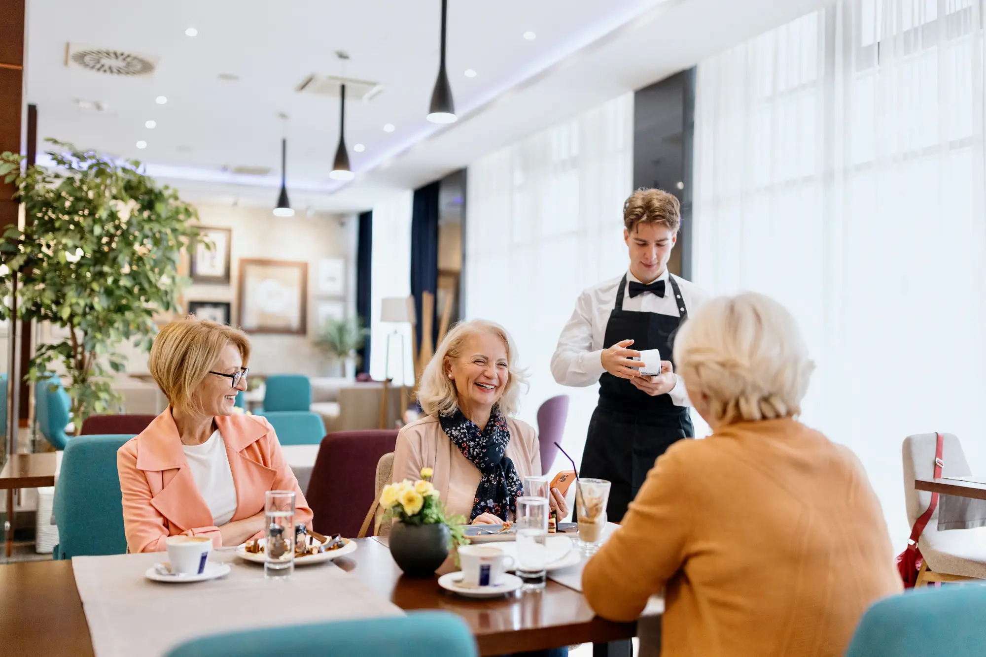 dining at The Clare Senior women out at a meal while a waiter takes their order