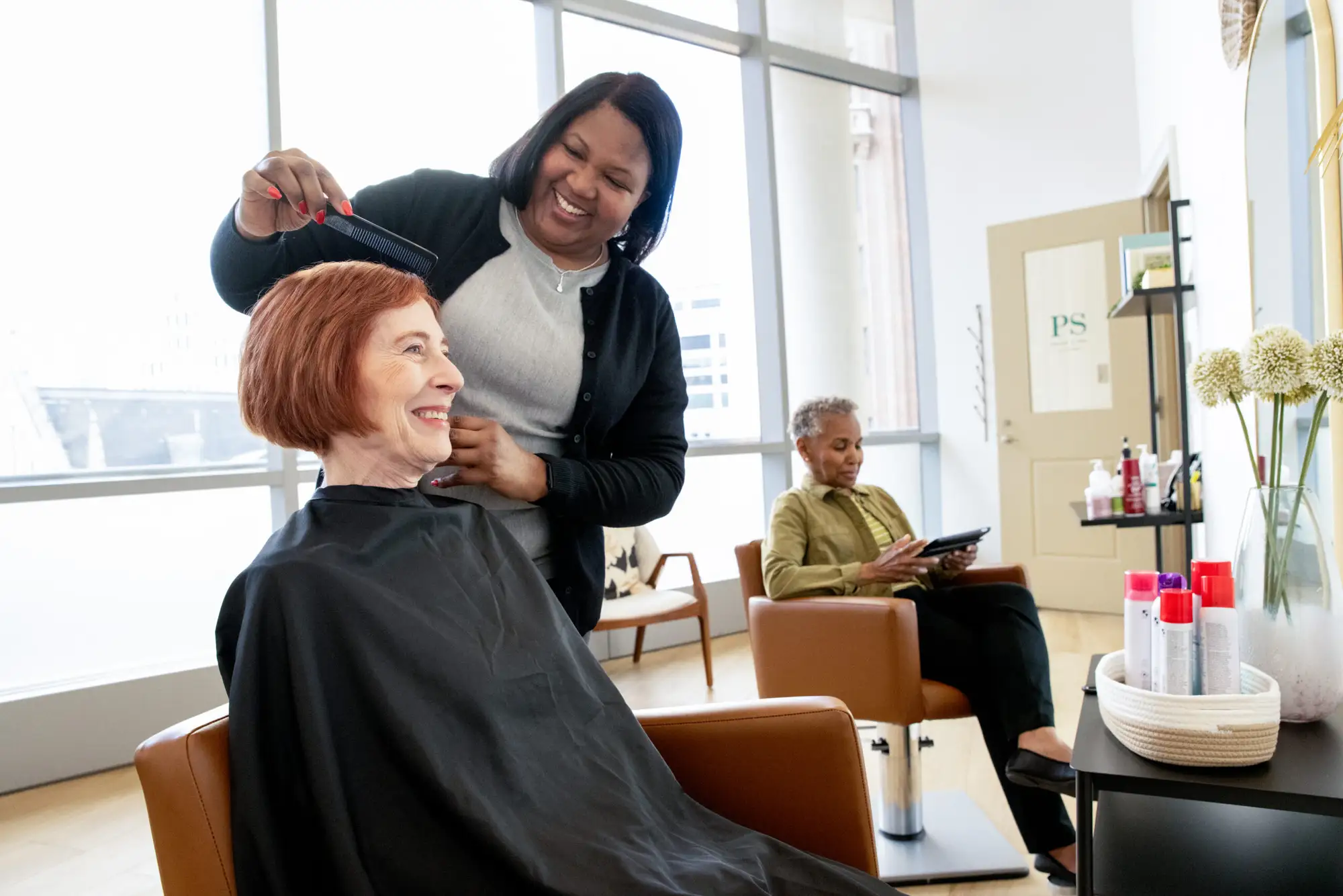 A resident of The Clare getting her hair done done while enjoying the luxury services & amenities in Independent Living In Chicago,IL.